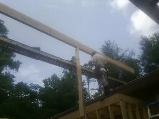 Carpenter setting a ridge beam over a new addition frame — Ice Dam Removal by Roofing Brothers in Hustisford