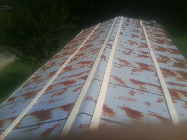 Rusted metal roof panels with new wood purlins before replacement — Storm Damage Roof Repair in Hustisford by Roofing Brothers