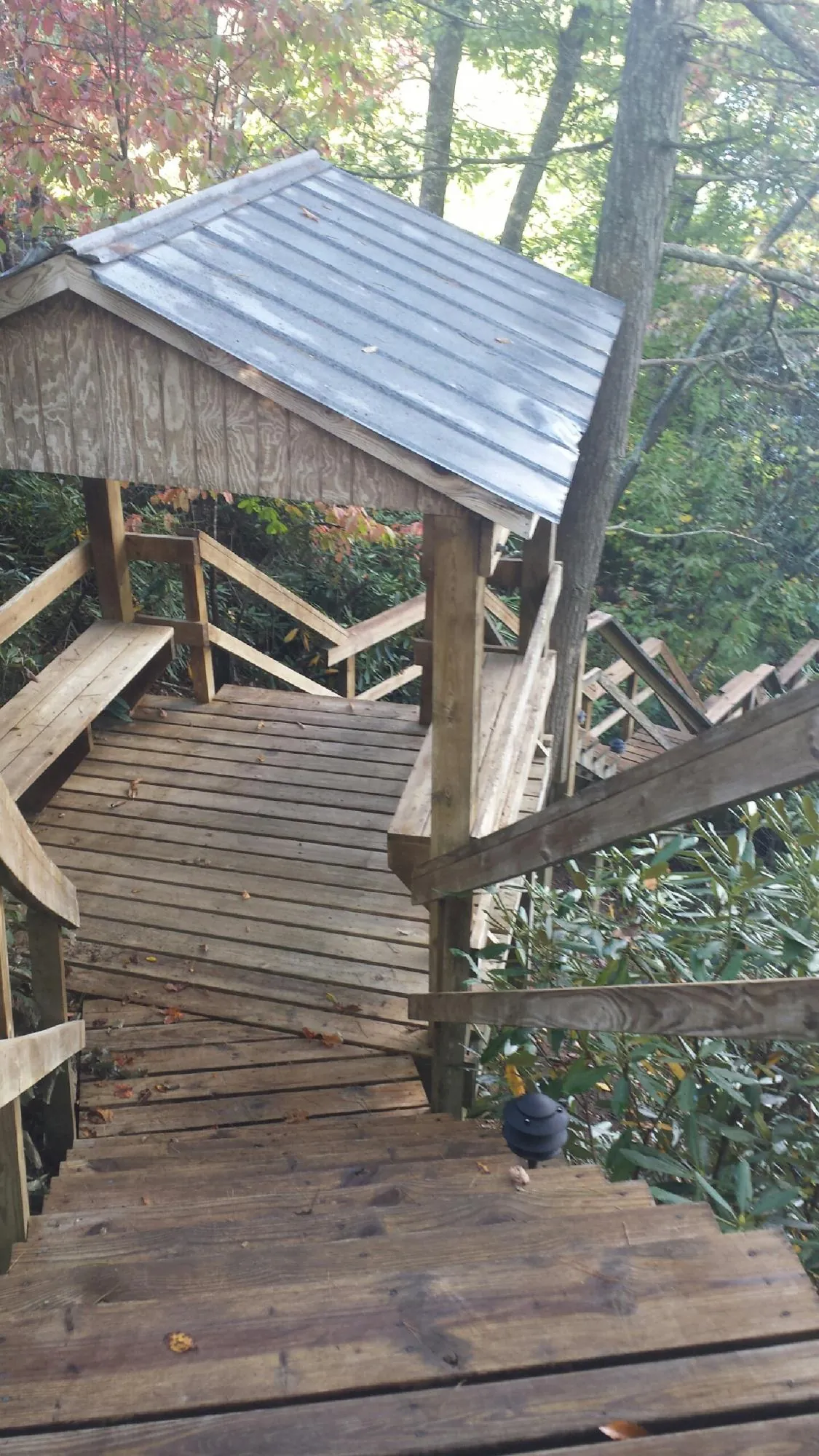 Metal roofed shelter over wooden steps on a wooded walkway — Skylight Repair & Installation work by our crew in Hustisford